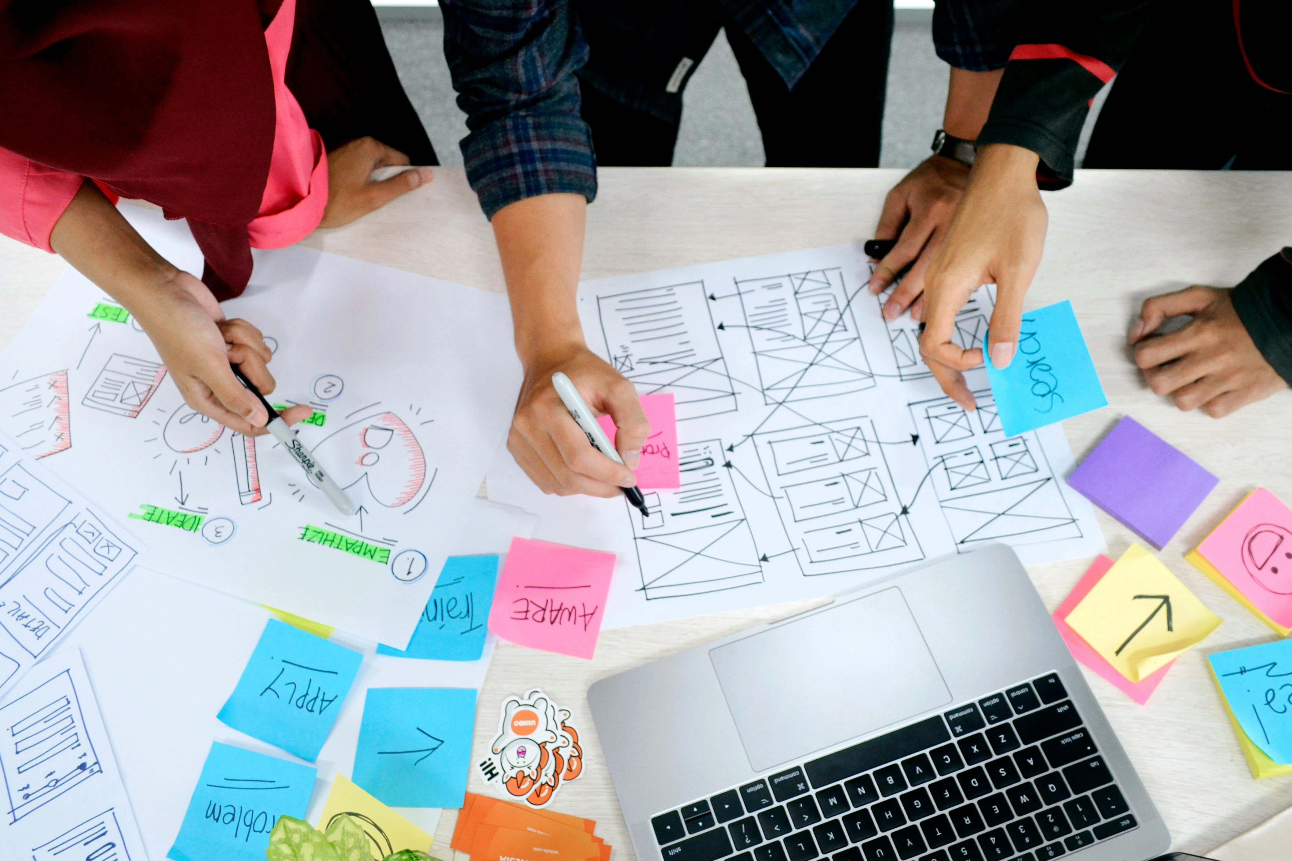 Un atelier de conception autour de post-its et d'ordinateurs